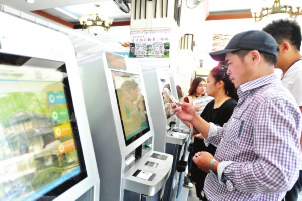 　　　　游客在自助机上购买入园门票。　□记者　杭兴微　摄
