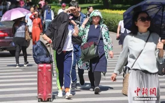 资料图：市民高在温晴天出行。中新社 贾天勇 摄