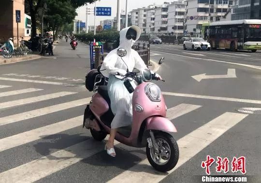 资料图：市民在高温下出行。崔佳明 摄