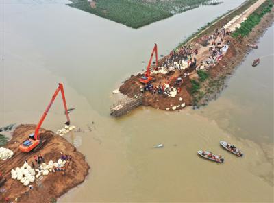 8月14日,寿光市清水泊农场三分厂弥河分流西坝,解放军、武警战士、党员干部、志愿者等近万人封堵弥河分流决口。图/视觉中国