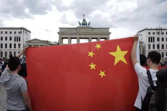 ▲德国华人和留学生高举五星红旗 (图via网络)