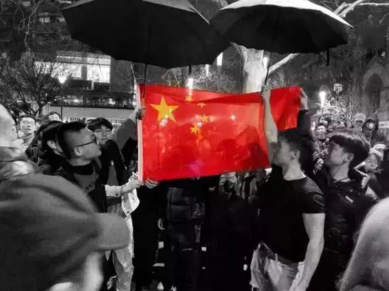 ▲中国留学生自发赶来,将乱港分子团团围住,他们高唱国歌,在雨夜中为国旗撑伞,手机/平板的屏幕上的国旗分外耀眼 (图via网络)