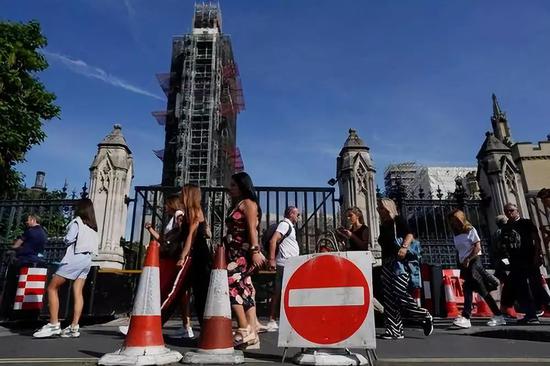 8月30日，在英国伦敦，行人路过议会大厦。新华社/欧洲新闻图片社