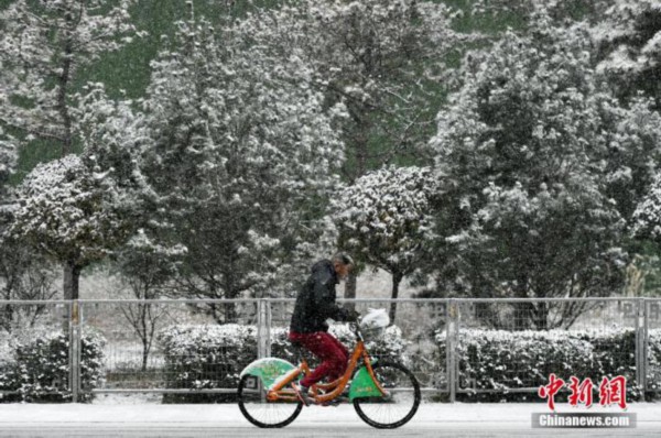 资料图：12月15日，山西省太原市迎来降雪天气，民众冒雪出行。韦亮 摄