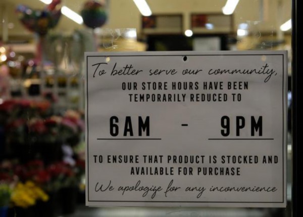 3月15日，在加州旧金山湾区，一家连锁超市贴出缩短营业时间加紧备货的通知。图据新华社