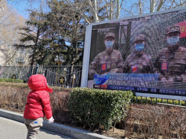 迟象阳的女儿芊芊在大屏幕前看有关妈妈的视频