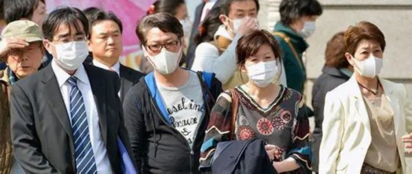  日本街头，人群佩戴口罩出行