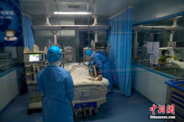 资料图：武汉大学人民医院里，医护人员为患者进行护理。中新社记者 张畅 摄