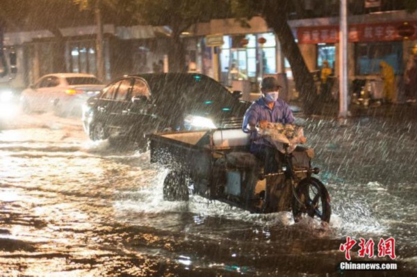 8月9日晚，北京市民冒雨涉水出行。当日，北京气象台发布18时至23时降水量（毫米）：全市平均17.9，城区平均28.1。大部地区出现7、8级阵风，局地达9到11级。 中新社记者 田雨昊 摄