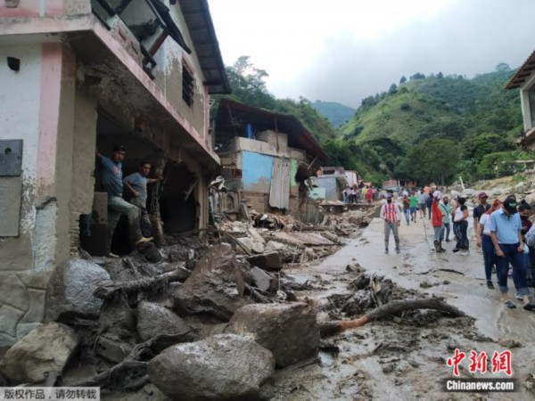 当地时间8月25日，委内瑞拉梅里达州民众在泥泞的道路上。