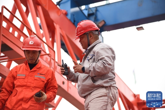  &uarr;杨兴义（右）在施工现场和工友讨论（1月24日摄）。新华社记者田建川摄