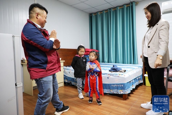 &uarr;杨兴义一家在板房宿舍里玩（1月24日摄）。新华社记者王瑞平摄