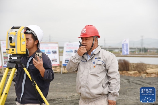 &uarr;杨兴义（右）在施工现场指引设备下桩（1月25日摄）。新华社记者田建川摄