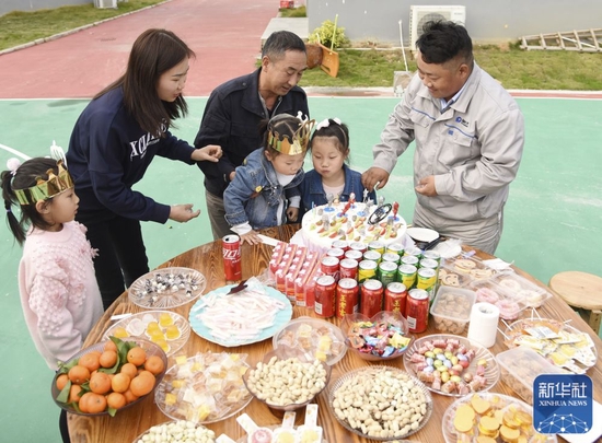 &uarr;在项目部操场上，杨兴义和留下来过年的工友们一起为小女儿庆祝生日（1月25日摄）。新华社记者田建川摄