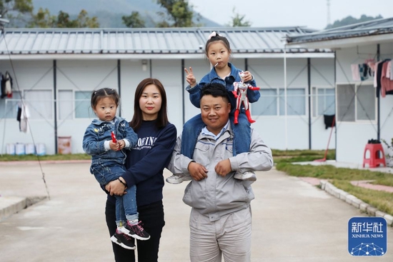  &uarr;杨兴义一家四口在板房宿舍前合影（1月25日摄）。新华社记者王瑞平摄