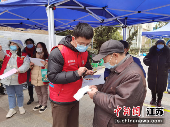网格员协助居民参与核酸检测。无锡市委政法委供图