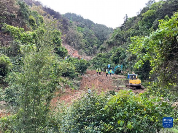 3月22日，在广西藤县埌南镇莫埌村，挖掘机开挖进入东航MU5735客机坠毁事故现场的通道，为后续工作铺平道路（手机照片）。新华社记者 周华 摄