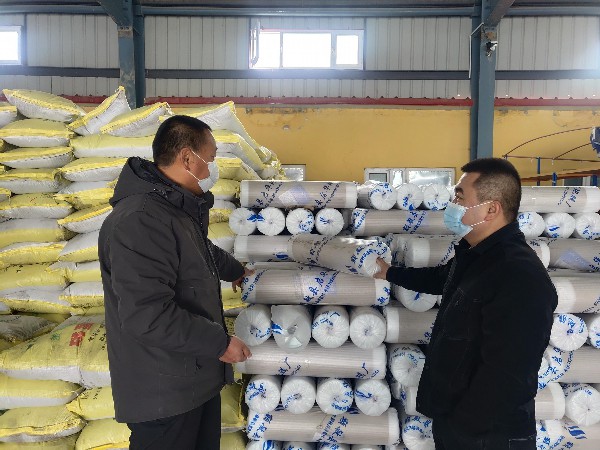 图为九师一六四团的职工正在购买地膜和化肥（苟汇敏　摄）