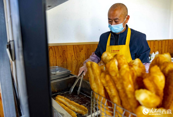 早餐店老板正在炸油条。人民网 次仁罗布摄