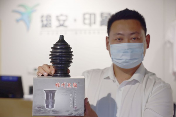 　&uarr;2022年9月6日，工作人员在展示雄安新区的文创纪念品。