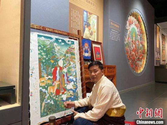 图为更登才让和他的作品。（资料图）　李玉峰　摄