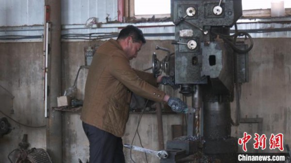 图为张朋在调试机器。　吕志敏 摄