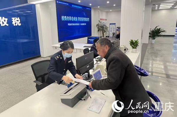 川渝高竹新区税费征管中心工作人员为纳税人开票。人民网 胡虹摄