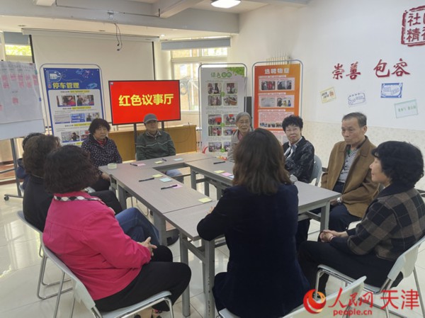 河西区越秀路街港云里社区红色议事厅里,居民代表正在讨论如何安装电动自行车充换电服务站的问题。人民网记者 孙翼飞摄