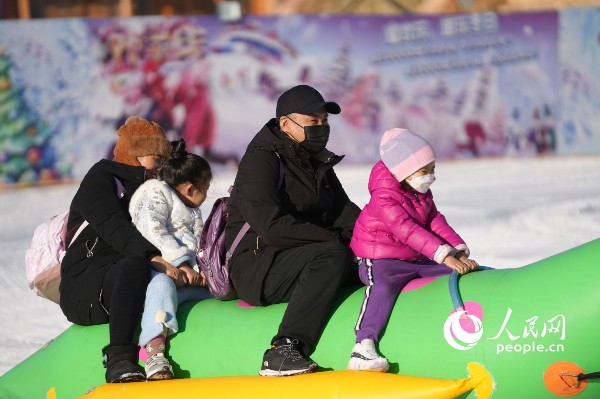 在北京市一大型游乐场里举办的“冰雪节”上,游客正在体验冰雪游乐项目。人民网记者 王天乐摄