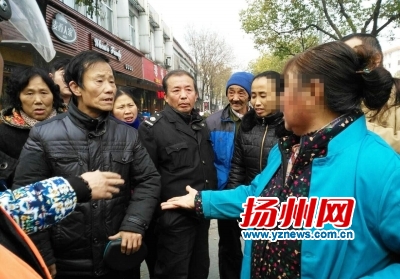 蓝衣大妈与李大爷（左二）争执。