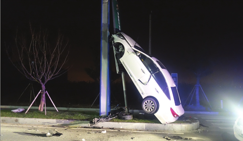 　　前日凌晨，一辆小轿车&ldquo;爬&rdquo;在路口的路灯杆上，车身呈70度直立，地上散落着车辆撞击产生的碎片。　□陈珺　摄