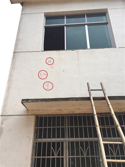 在凶案发生的房子外侧，警方至少标记11处符号（红圈处）。新京报记者 罗婷 摄
