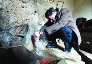 唐子培正在螃蟹眼泉取水点取水，以观测水氡、水汞变化