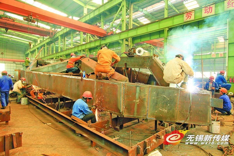 　　　一线员工正在加工钢结构构件。　（朱伟名　摄）