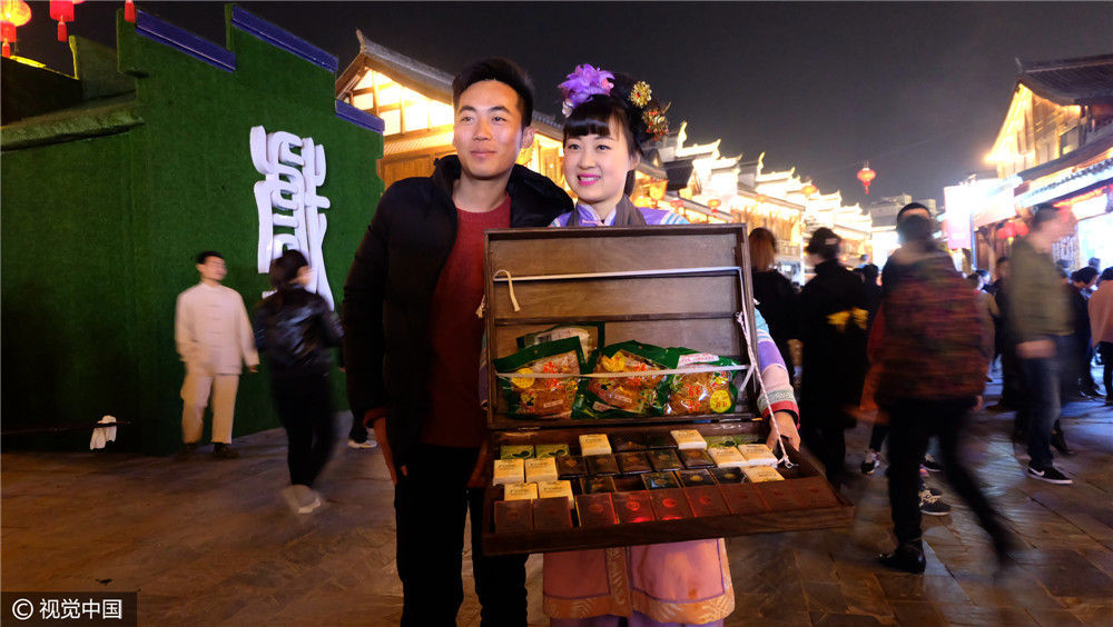 湖南常德市城区河街上人来人往,一位女孩穿着古装,装扮成古时的小商贩