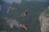 2018年7月22日，在宁夏贺兰山国家森林公园，杂技演员正在一条200多米长、距谷底150米的钢丝绳上，表演自行车骑行特技。