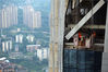 2018年10月12日，重庆，位于渝中区朝天门的重庆来福士在建项目举办了首个开放日暨摄影爱好者专场，来自全市的35位摄影爱好者受邀登上250多米高的“水晶连廊”。图为工人在百米高空上作业。视觉中国
