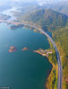 2018年10月12日，蜿蜒在千岛湖中的江西九江的永武高速公路与庐山西海秋意渐浓的植被交相辉映（无人机航拍）。