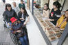 2018年10月12日，江苏无锡，工作人员向老人赠送重阳糕。龙巍/视觉中国