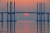2017年12月25日，青岛市胶州湾，火红的落日与跨海大桥构成唯美画卷。
大桥起自青岛主城区海尔路，经红岛到黄岛，大桥全长36.48公里，其中海上段长度25.171 公里。