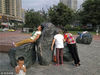 2016年08月15日，陕西省西安市，东南城角环城公园的小广场上，几名大妈趴在或躺在被太阳晒热的景观石上“冬病夏治”。