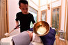 2017年7月24日，福州御瑜伽道会所的私人教练正在给顾客做“颂钵”理疗。颂钵源自喜玛拉雅山区，西藏颂钵原本是僧侣当作食器用途的器具。