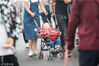 2018年10月5日，杭州，西湖景区，家长推着熟睡的孩子走在拥挤的人群中。