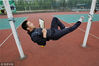 2012年5月7日，重庆师范大学，不到一指粗的尼龙绳，王启可以躺在上面看书睡觉加练功。（注：拍摄时有学校老师陪同并预备了防护措施。）渝友/视觉中国