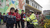 2018年11月30日，在安徽省郎溪经济开发区智慧幼儿园内，民警正在给一名排队乘车的幼儿整理书包。