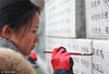 2018年12月9日，南京，南京高校的同学们在为“哭墙”上遇难同胞的名字“描红”。