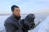 2018年12月11日，黑龙江省哈尔滨市，松花江上，采冰者们弯腰拉绳，宛如纤夫般拽重达半吨的冰块出水。采冰者都是自哈市江北万宝、东发、沙陀子等乡镇的农民，他们每年冬闲时都会亲属、村邻之间结伴到松花江畔采冰，有的采冰人，已经连续干了二十多年。每个采冰季，他们每天要在冰面上工作10-12个小时，每个采冰组，一天要拽出冰块2000-3000块，一个近20天的采冰季，每人能收入近万元。