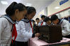 2018年12月17日，在山东省滨州市博兴县第一小学，小学生在“纪念改革开放四十周年物品展览”上观看各种老式物品。