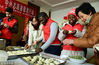 2018年12月31日，江苏镇江，江苏大学的外国留学生和镇江市红光社区志愿者在为养老中心的老人包饺子。