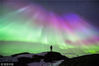 2015年12月9日消息（具体拍摄时间不详），挪威Hemnesberget，北极光照亮星空，37岁的摄影师Tommy Eliassen为拍摄北极光，帐篷露营，对抗着寒冷的天气。绿色和紫色的北极光与Tommy Eliassen的轮廓身影形成对比反差。